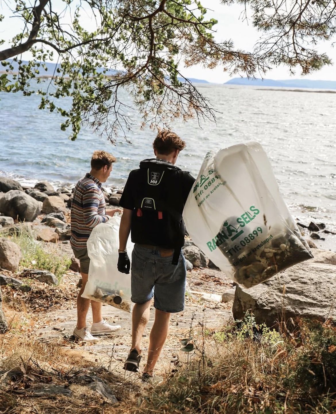 People clearing waste from a shoreline.